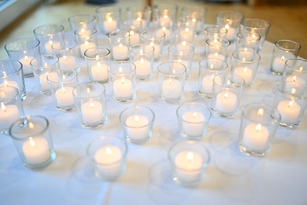 Auf dem Bild sieht man viele Kerzen auf einem Tisch.