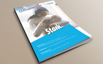 Auf dem Bild sieht man eine Skulptur aus Holz, mit dem Motiv einer Mutter die ihr Kind im Arm hält.