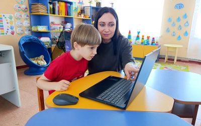 Auf dem Bild sieht man eine Frau und einen Jungen an einem Laptop.